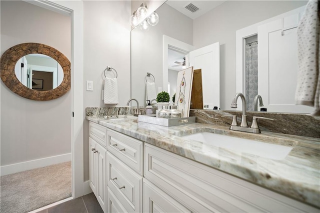 bathroom with tile patterned flooring, vanity, and ceiling fan