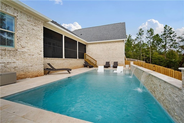 view of pool featuring a sunroom, a patio area, and pool water feature