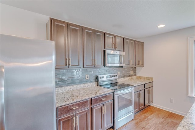 3473 Summer Woods Cir W, Mobile, AL 36695 - kitchen with appliances with stainless steel finishes, light wood-style floors, decorative backsplash, baseboards, and recessed lighting