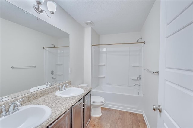 3473 Summer Woods Cir W, Mobile, AL 36695 - bathroom with toilet, wood finished floors, double vanity, tub / shower combination, and a textured ceiling