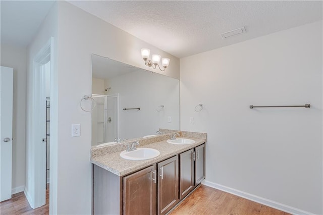 3473 Summer Woods Cir W, Mobile, AL 36695 - full bath with wood finished floors, a shower with door, double vanity, a textured ceiling, and baseboards