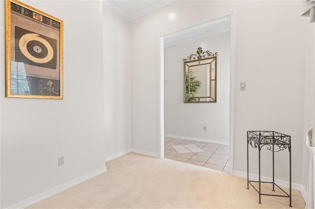 unfurnished room featuring tile patterned flooring, carpet flooring, baseboards, and ornamental molding