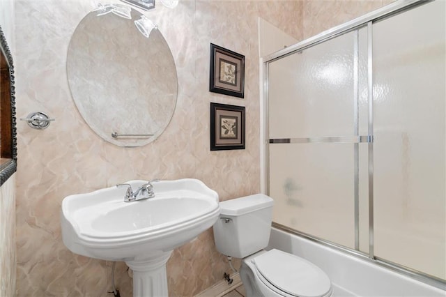 bathroom with enclosed tub / shower combo and toilet