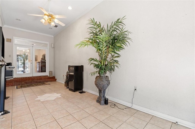 interior space featuring light tile patterned floors, baseboards, lofted ceiling, ceiling fan, and ornamental molding