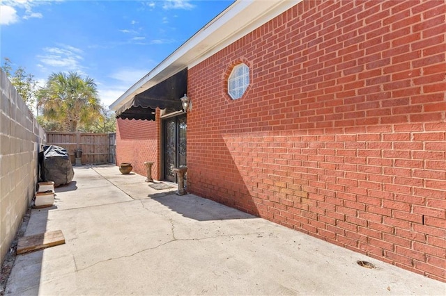 exterior space with a patio, a fenced backyard, and brick siding