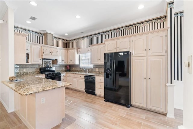 kitchen with visible vents, black appliances, a sink, a peninsula, and light stone countertops