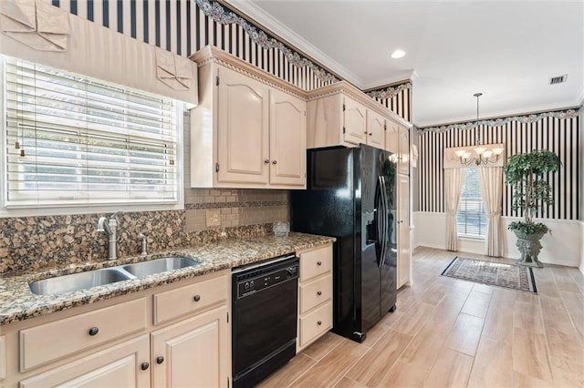 kitchen featuring visible vents, black appliances, ornamental molding, a sink, and an inviting chandelier