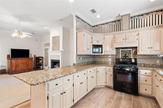 kitchen featuring light stone counters, visible vents, a peninsula, built in microwave, and black gas range