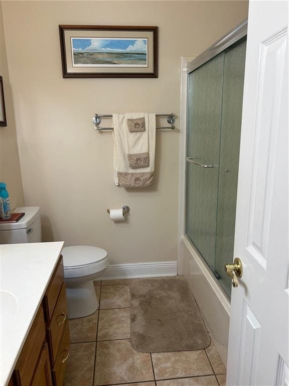 full bathroom with bath / shower combo with glass door, vanity, toilet, and tile patterned floors