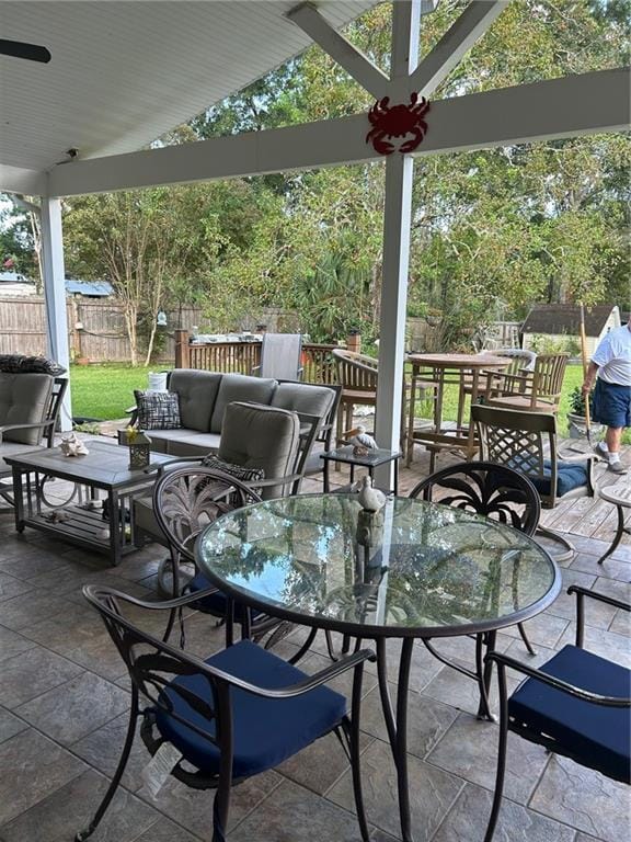 view of patio / terrace with an outdoor living space, outdoor dining space, and fence