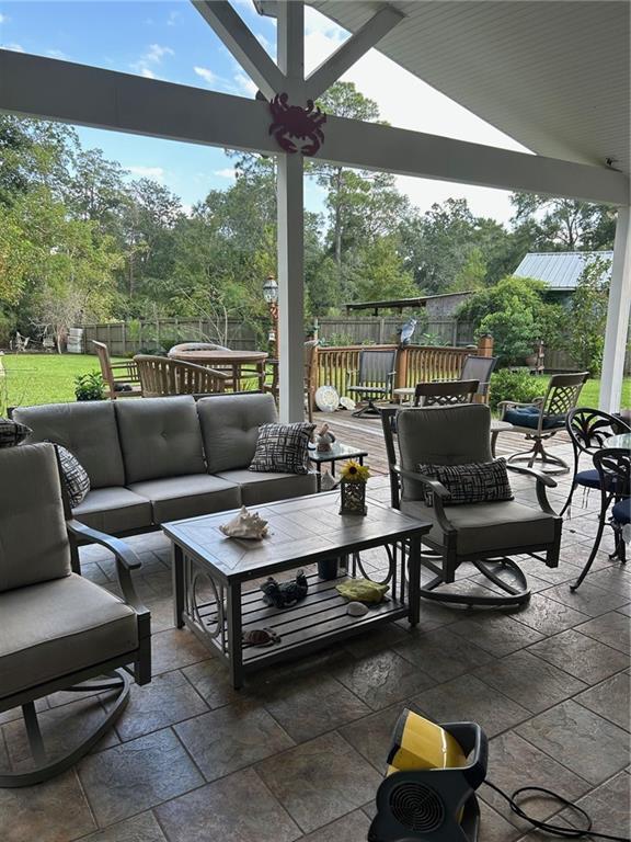 view of patio with an outdoor living space and fence