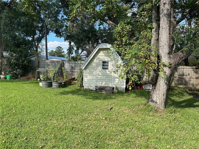 view of yard featuring a storage shed, an outbuilding, and a fenced backyard