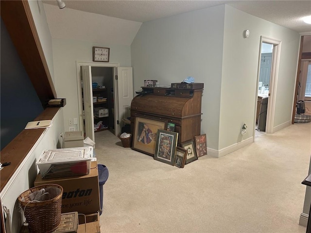 hallway with lofted ceiling and light carpet