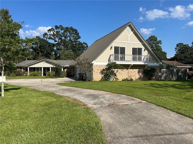 view of side of property with brick siding, driveway, and a lawn