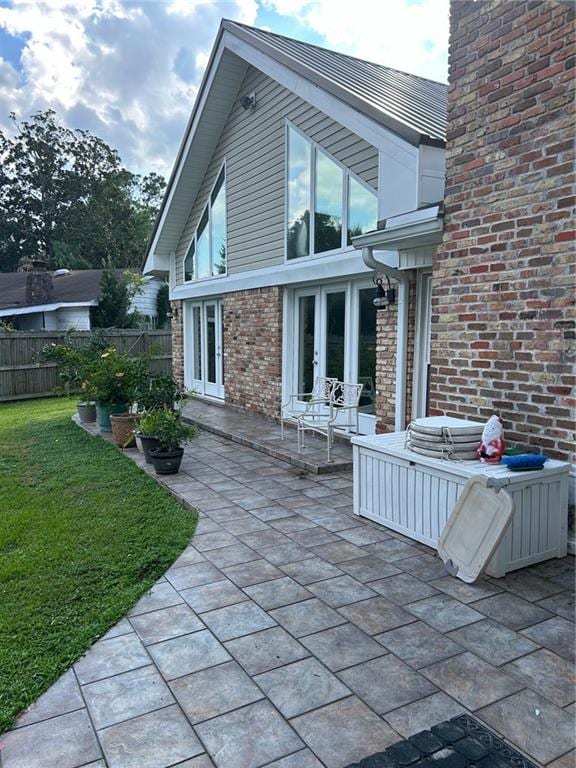 back of house featuring french doors, a lawn, and a patio