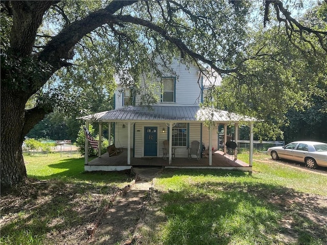 farmhouse inspired home featuring covered porch and a front yard