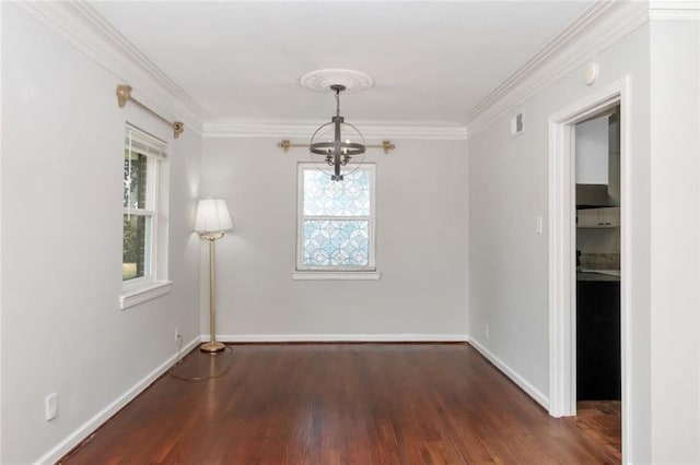 unfurnished dining area with a chandelier, plenty of natural light, ornamental molding, and wood finished floors