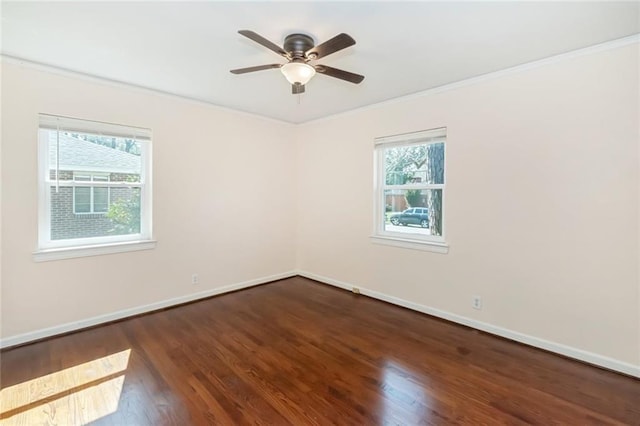 empty room with ornamental molding, a ceiling fan, baseboards, and wood finished floors