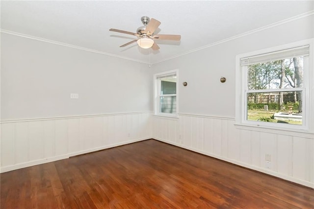 unfurnished room featuring wainscoting, crown molding, ceiling fan, and wood finished floors