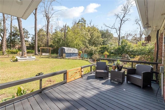 wooden deck featuring a storage shed, an outbuilding, a lawn, and fence