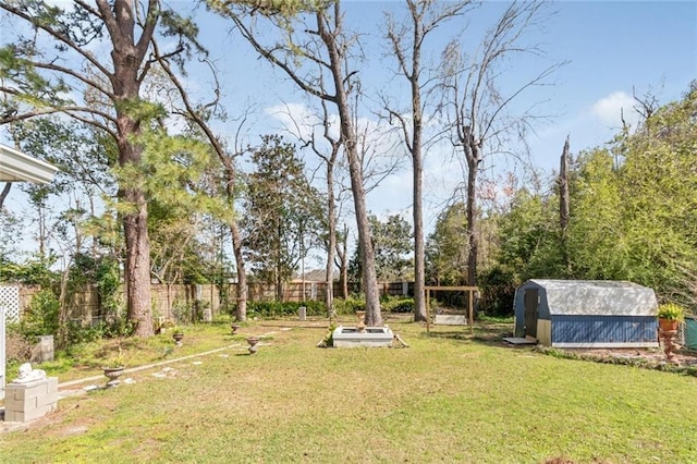 view of yard featuring a storage shed, an outdoor structure, and fence