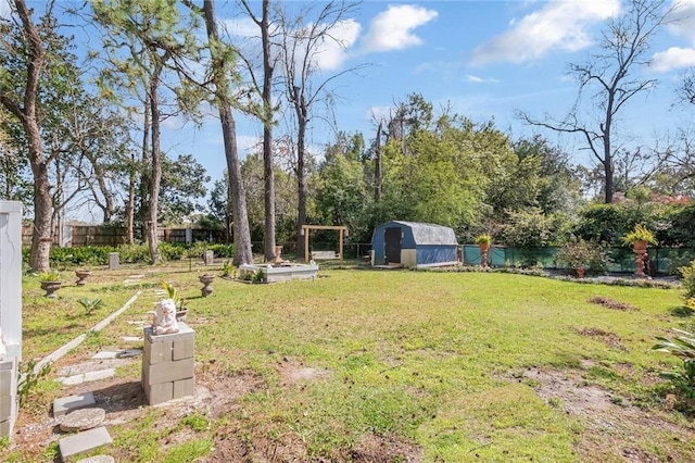 view of yard with an outdoor structure, a fenced backyard, and a shed