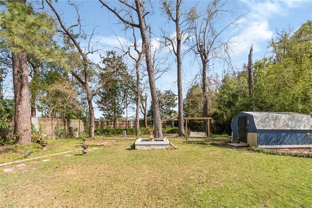 view of yard with an outdoor structure, fence, and a shed