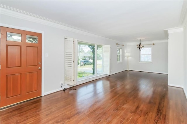 foyer entrance featuring crown molding, a notable chandelier, wood finished floors, and baseboards