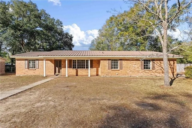 view of front of property featuring brick siding and metal roof