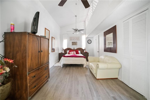 bedroom with ceiling fan, light wood-type flooring, a wall unit AC, and high vaulted ceiling