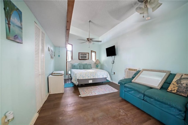 bedroom with a textured ceiling, ceiling fan, dark hardwood / wood-style flooring, and lofted ceiling