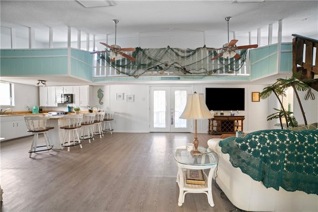 living room with ceiling fan, a high ceiling, and a wealth of natural light