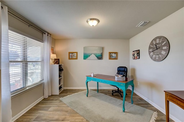 home office with light hardwood / wood-style floors