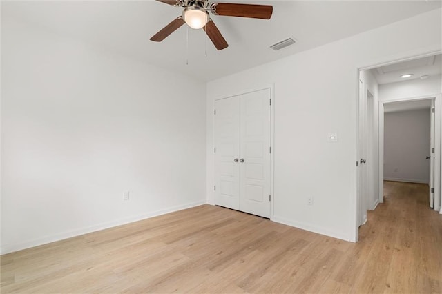 unfurnished bedroom with a closet, baseboards, light wood-style flooring, visible vents, and ceiling fan