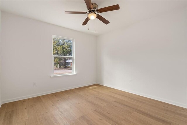 empty room featuring baseboards, light wood finished floors, and ceiling fan