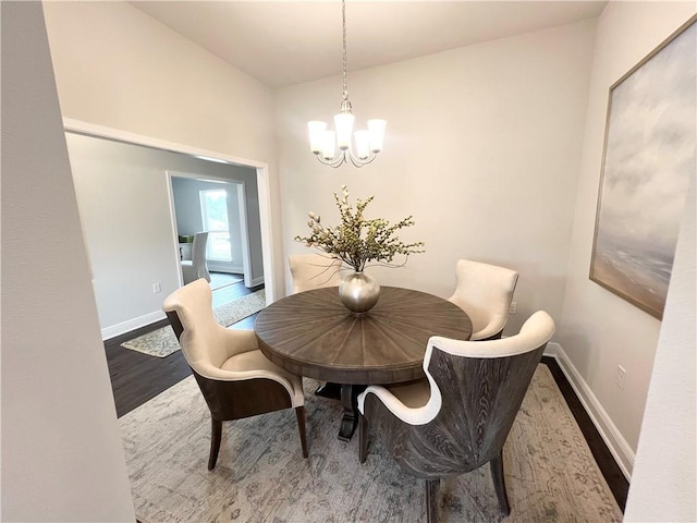 dining area featuring a notable chandelier, wood finished floors, and baseboards