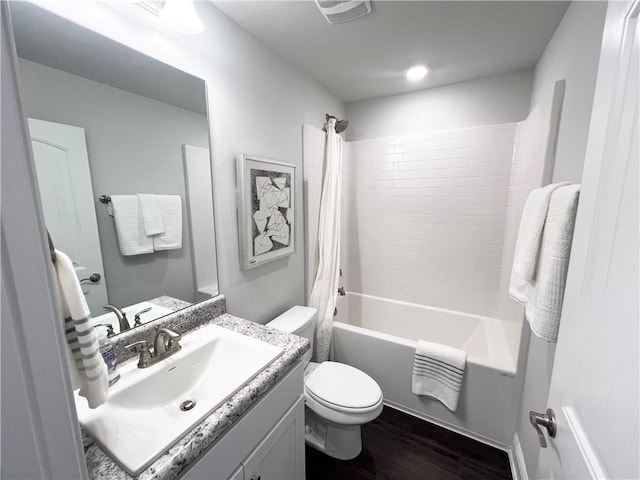 bathroom with visible vents, toilet, shower / bath combo, wood finished floors, and vanity