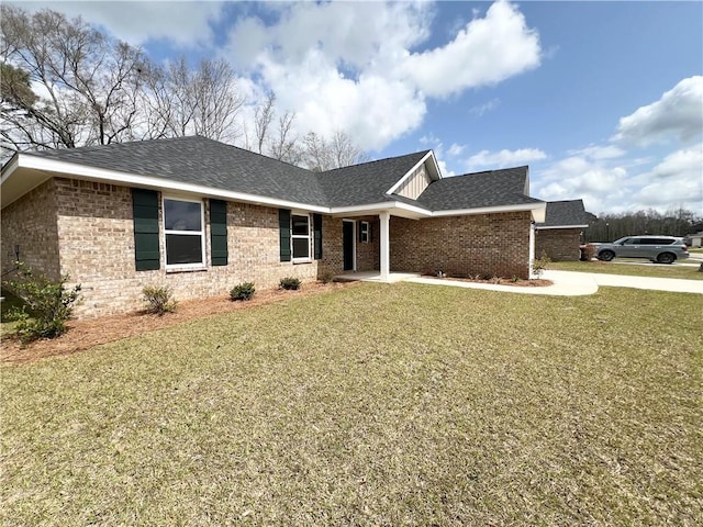 ranch-style home with driveway, brick siding, roof with shingles, and a front lawn