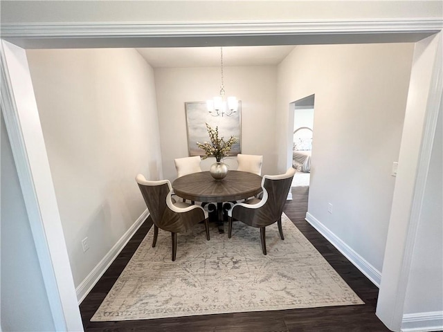 dining space featuring a notable chandelier, dark wood-type flooring, and baseboards