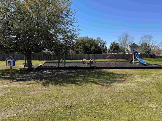 view of yard featuring playground community and fence