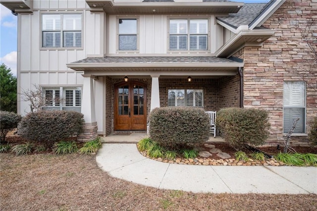 view of exterior entry with covered porch and french doors