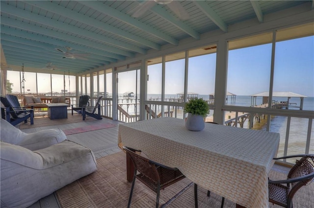 sunroom with wooden ceiling, a water view, ceiling fan, and beamed ceiling