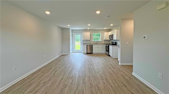 kitchen featuring white cabinets, light hardwood / wood-style floors, sink, and appliances with stainless steel finishes