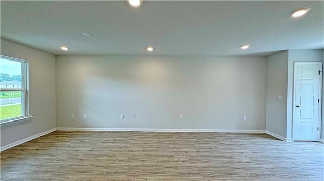 empty room featuring light wood-type flooring and a healthy amount of sunlight