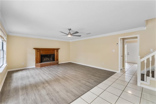 unfurnished living room featuring a brick fireplace, light hardwood / wood-style flooring, and crown molding