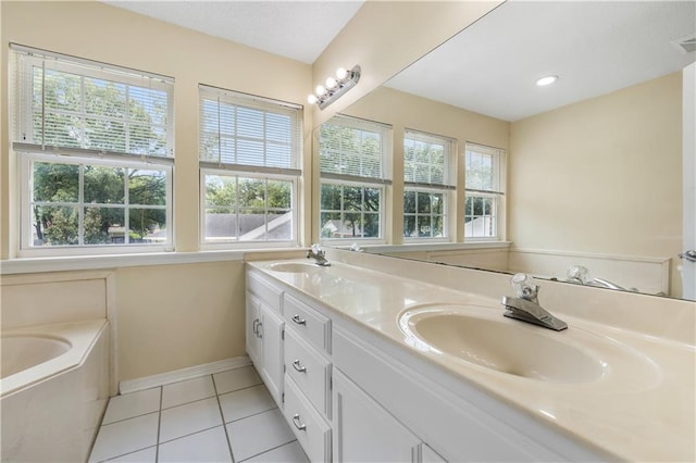 bathroom with a bathing tub, tile patterned flooring, plenty of natural light, and vanity