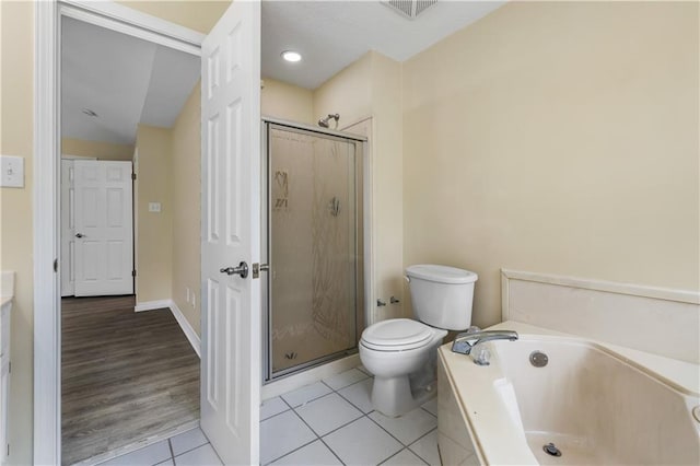 bathroom with toilet, plus walk in shower, and tile patterned floors