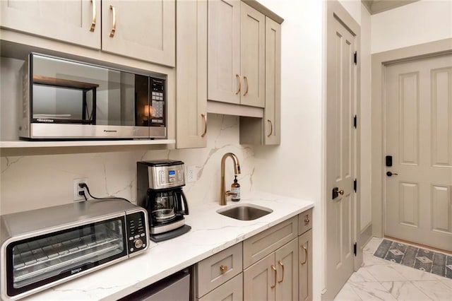 kitchen featuring gray cabinets, light tile patterned flooring, decorative backsplash, sink, and stainless steel microwave