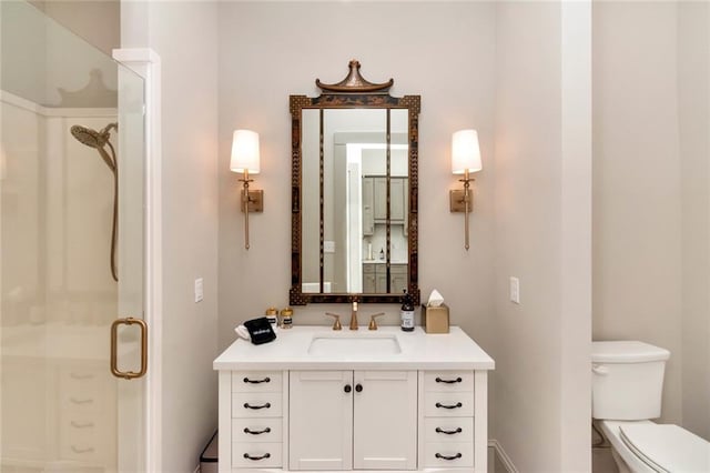 bathroom featuring a shower with door, toilet, and vanity