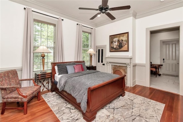 bedroom with hardwood / wood-style flooring, crown molding, and ceiling fan